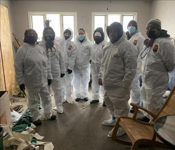 A group of our SERVPRO employees wearing hazmat suits at a job site.