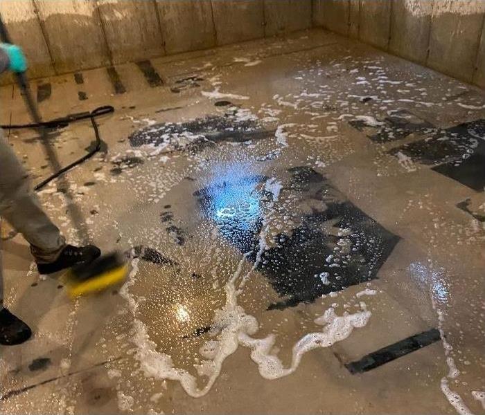 An Albany basement being cleaned with soap after a flood.