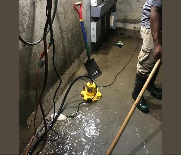 A flooded basement in Albany, NY with one of our SERVPRO techs working.