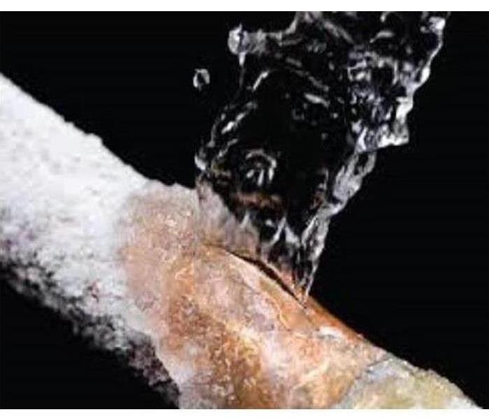 A frozen pipe bursting with water.