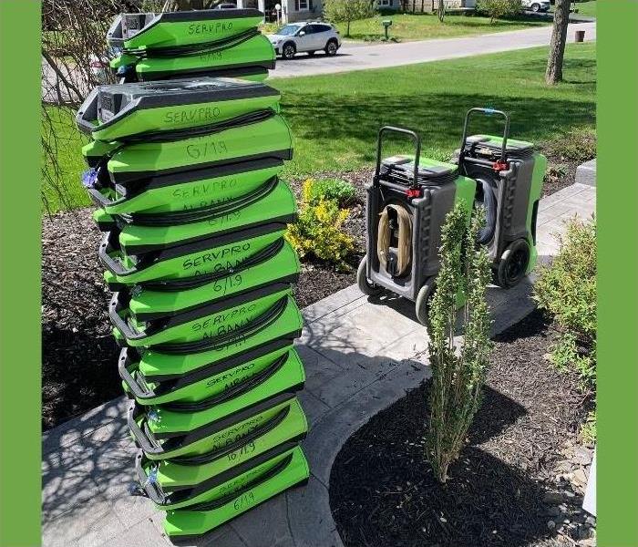 A stack of our SERVPRO air movers and a few dehumidifiers outside of a Saratoga home.